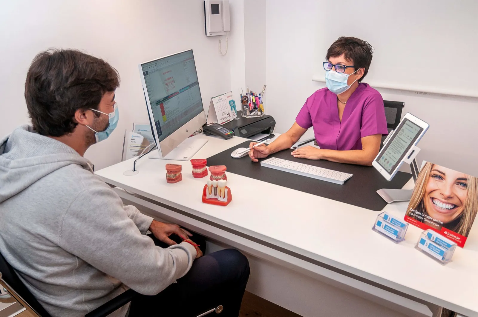 Consulta en Clínica Dental San Salvador con modelos de dientes e implantes sobre la mesa