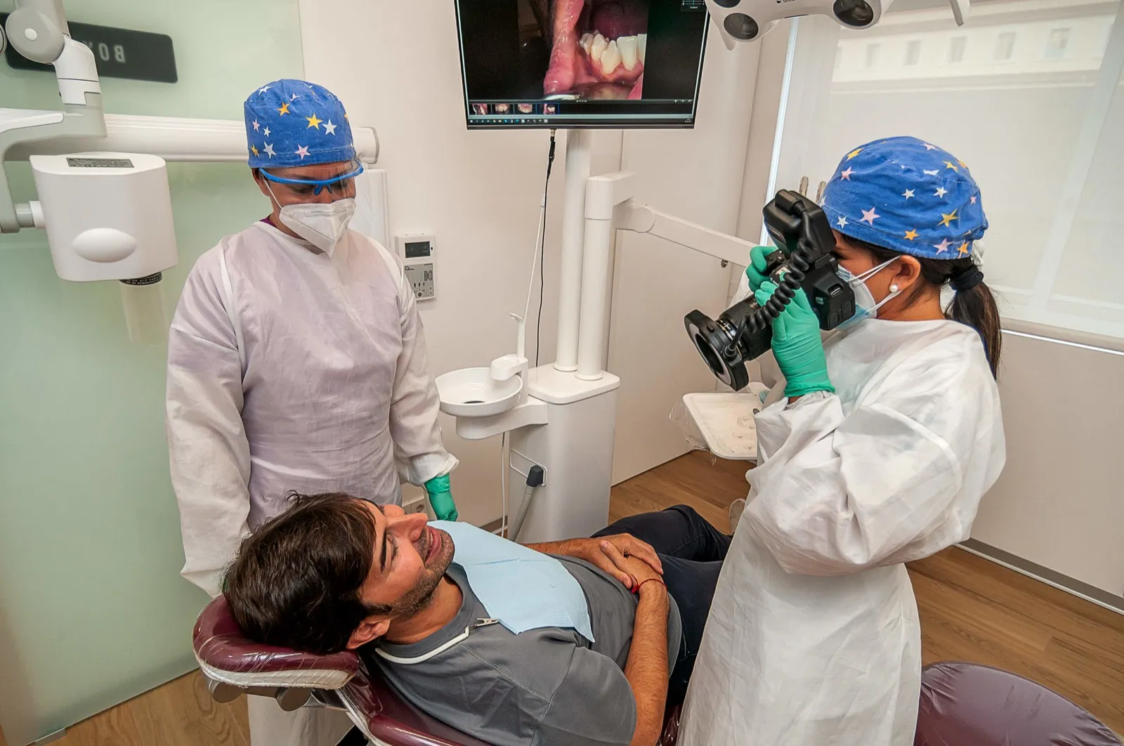 Dos profesionales de Clínica Dental San Salvador realizando el registro fotográfico intraoral de un paciente