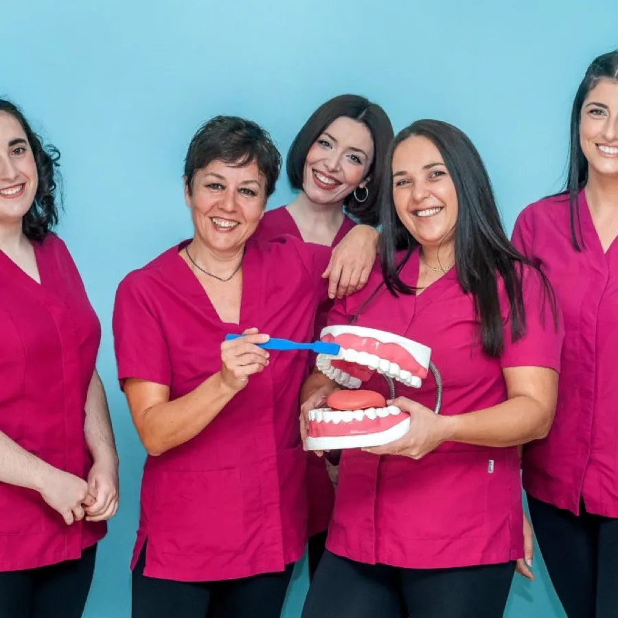 Equipo de auxiliares e higienistas de Clínica Dental San Salvador con un modelo dental